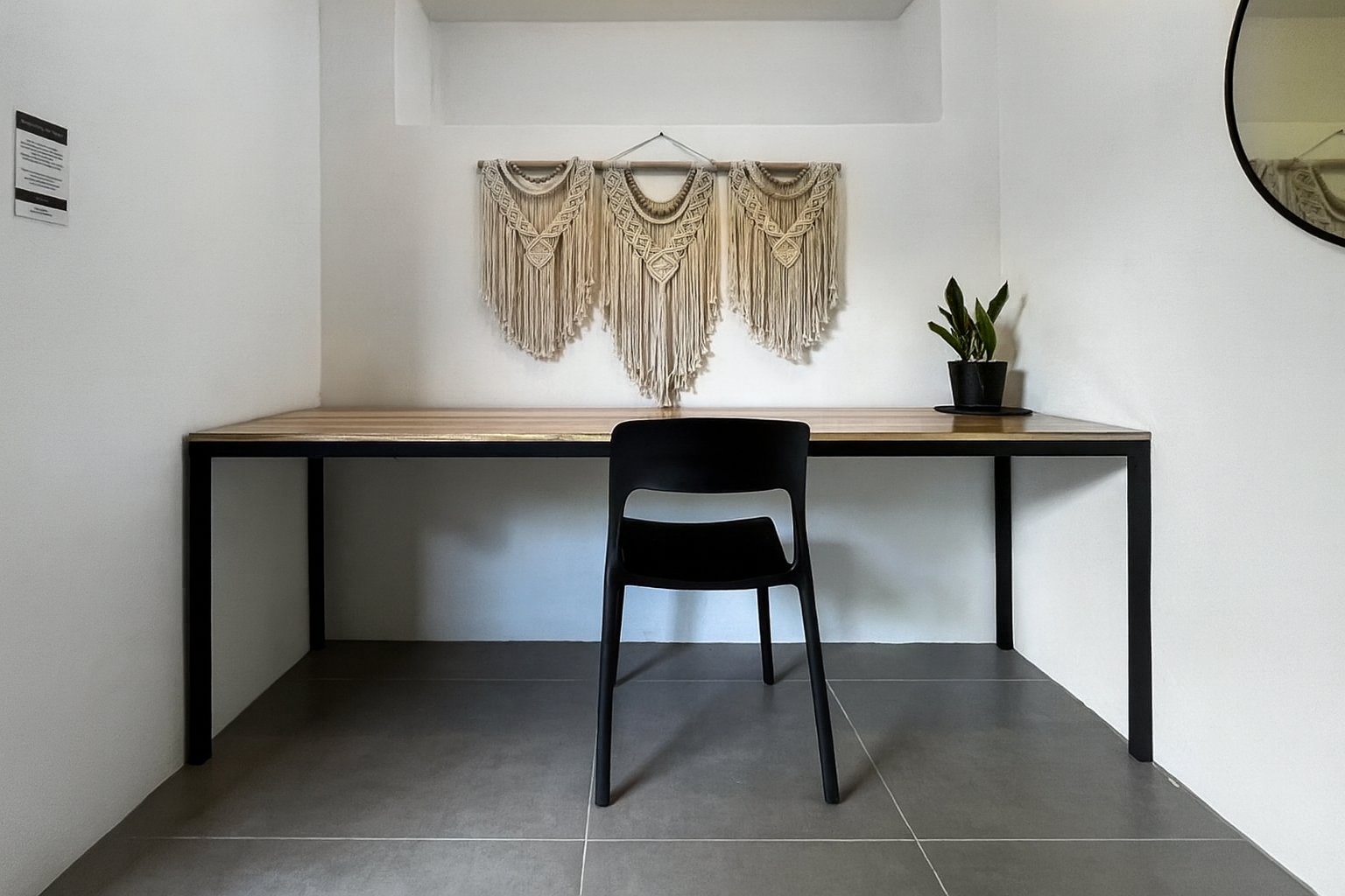 Private work studio interior with wood-and-steel desk and macramé wall art at Spaces Ojochal
